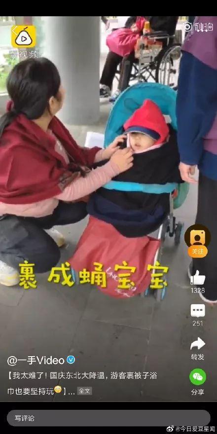 气温骤降女子裹棉被逛景区,东北降温游客裹被子玩耍